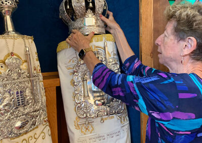 Judith Ehrenstaft adjusting crown on a Torah